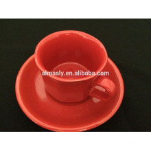 Taza de cerámica esmaltada de colores calientes y platillo